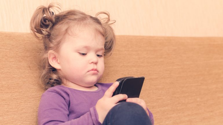 Petite fille qui joue sur un smartphone